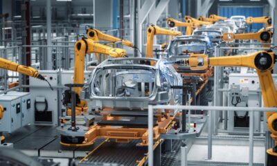 Linea di assemblaggio automatizzata con bracci robotici.