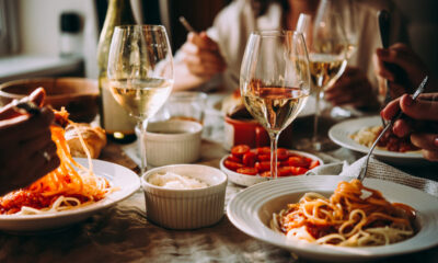 Persone gustano pasta e vino a cena in un ambiente accogliente