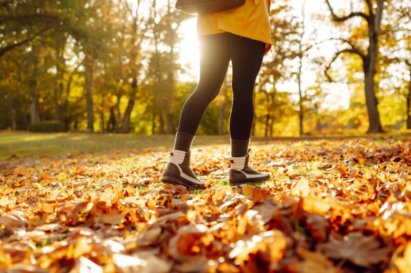Donna cammina in parco in autunno