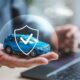 Rappresentazione del concetto di assicurazione auto con modellino di automobile e icona di sicurezza.