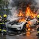 Auto elettrica in fiamme alla colonnina con vigili del fuoco in azione