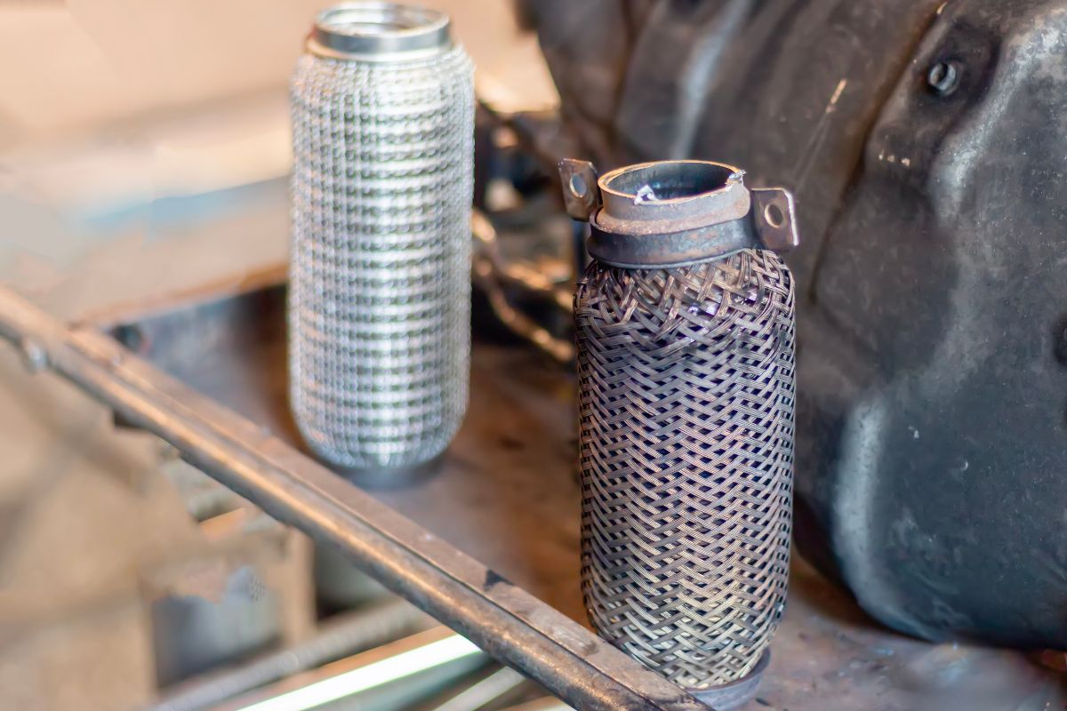 Primo piano di un filtro antiparticolato per diesel, danneggiato e nuovo.