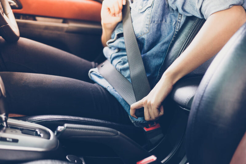Passeggero allaccia una cintura di sicurezza in auto