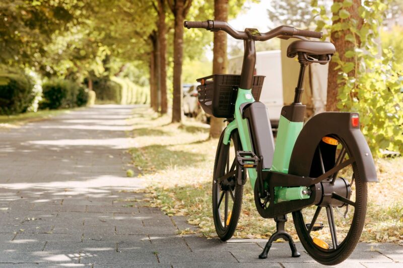 Una bici elettrica parcheggiata in un viale alberato.