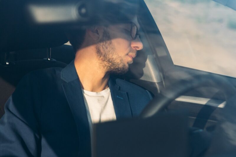 Un uomo d'affari stanco dorme seduto nella sua auto.