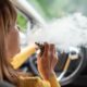 Donna fuma una sigaretta elettronica in auto