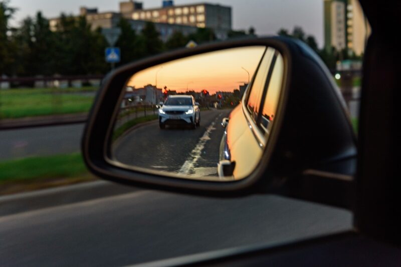 Specchietto auto laterale che riflette il traffico alle spalle