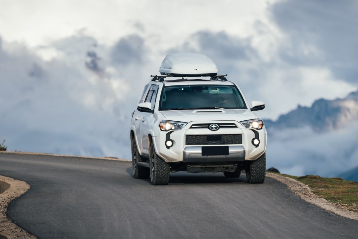 Suv bianco percorre una strada di montagna.