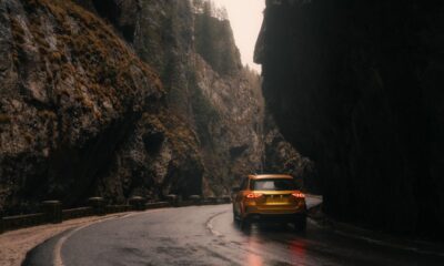 Auto gialla percorre una strada di montagna.