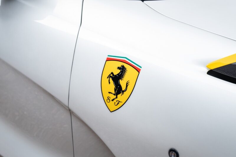 Logo Ferrari applicato su una carrozzeria bianca.