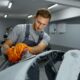 Operaio ripara la carrozzeria di un'auto in officina.