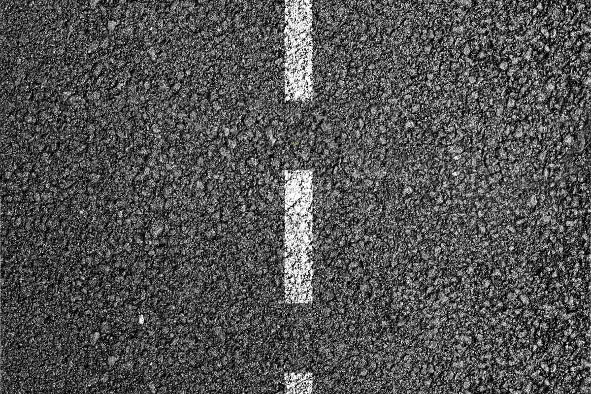 Strada in asfalto con linea tratteggiata.