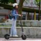 Ragazza su un monopattino elettrico con il casco.