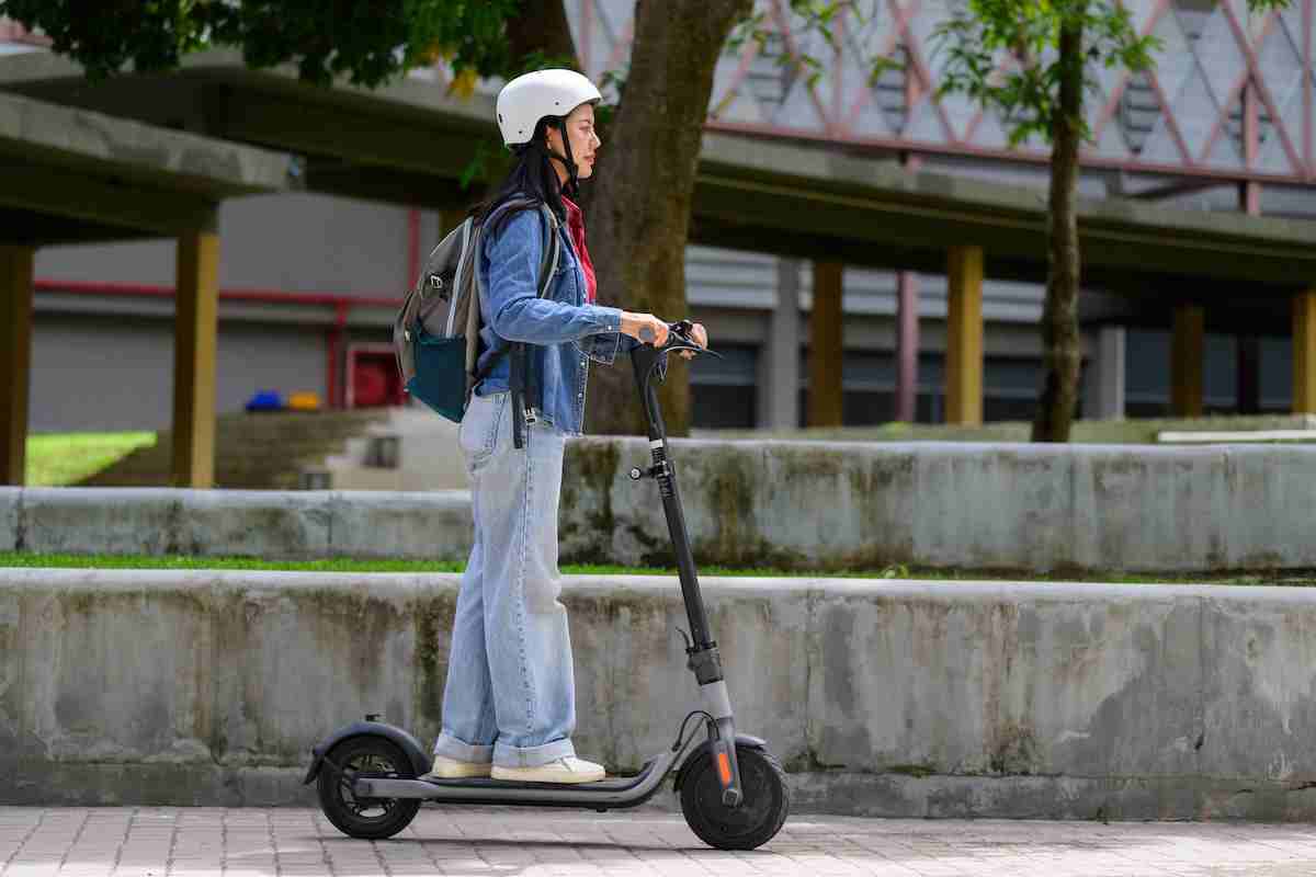 Ragazza su un monopattino elettrico con il casco.