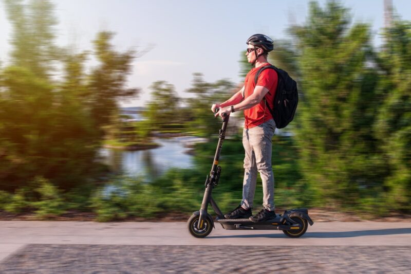 Ragazzo su un monopattino elettrico con il casco.